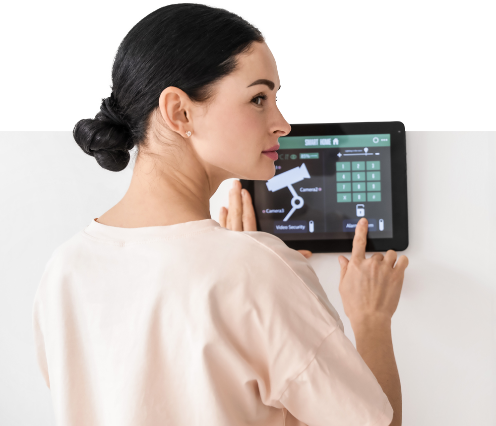 A woman is using a tablet to control a security system