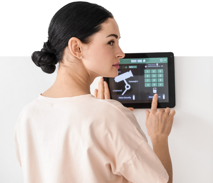 A woman is using a tablet to control a security system