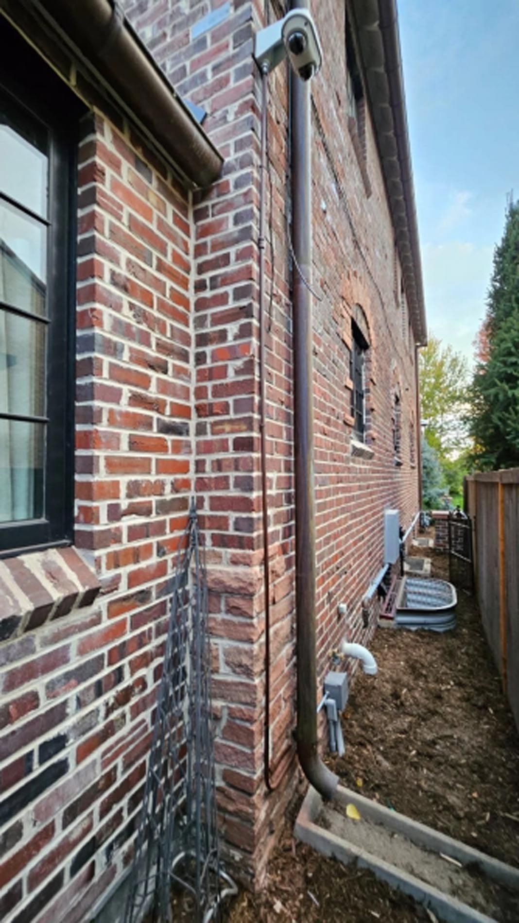A brick building with a drain pipe on the side of it.