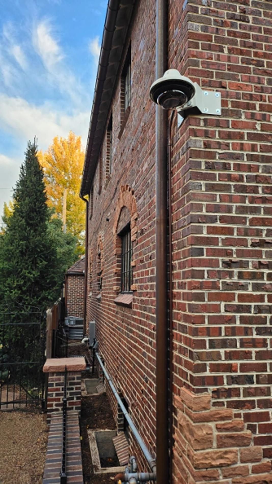 A brick building with a security camera on the side of it.