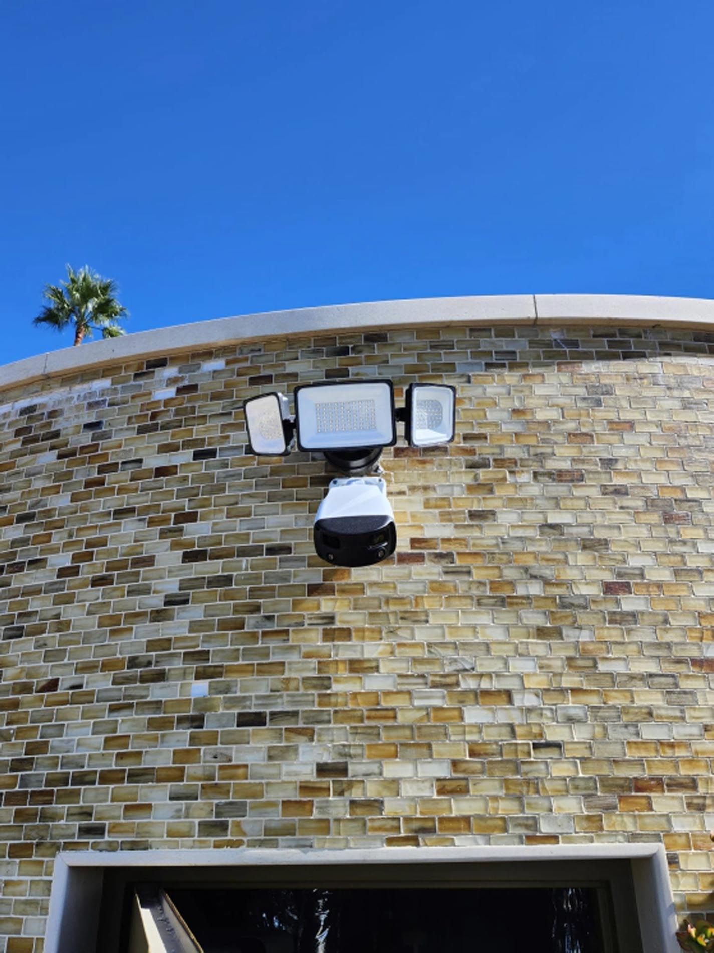 A brick wall with a security camera mounted on it