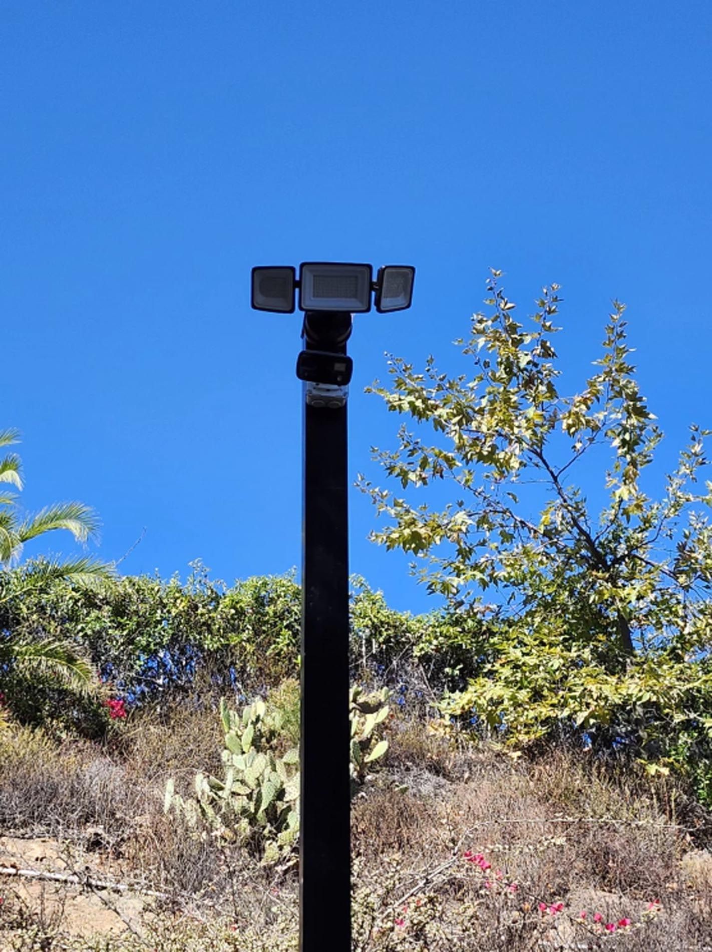 A pole with a light on it in the middle of a field.