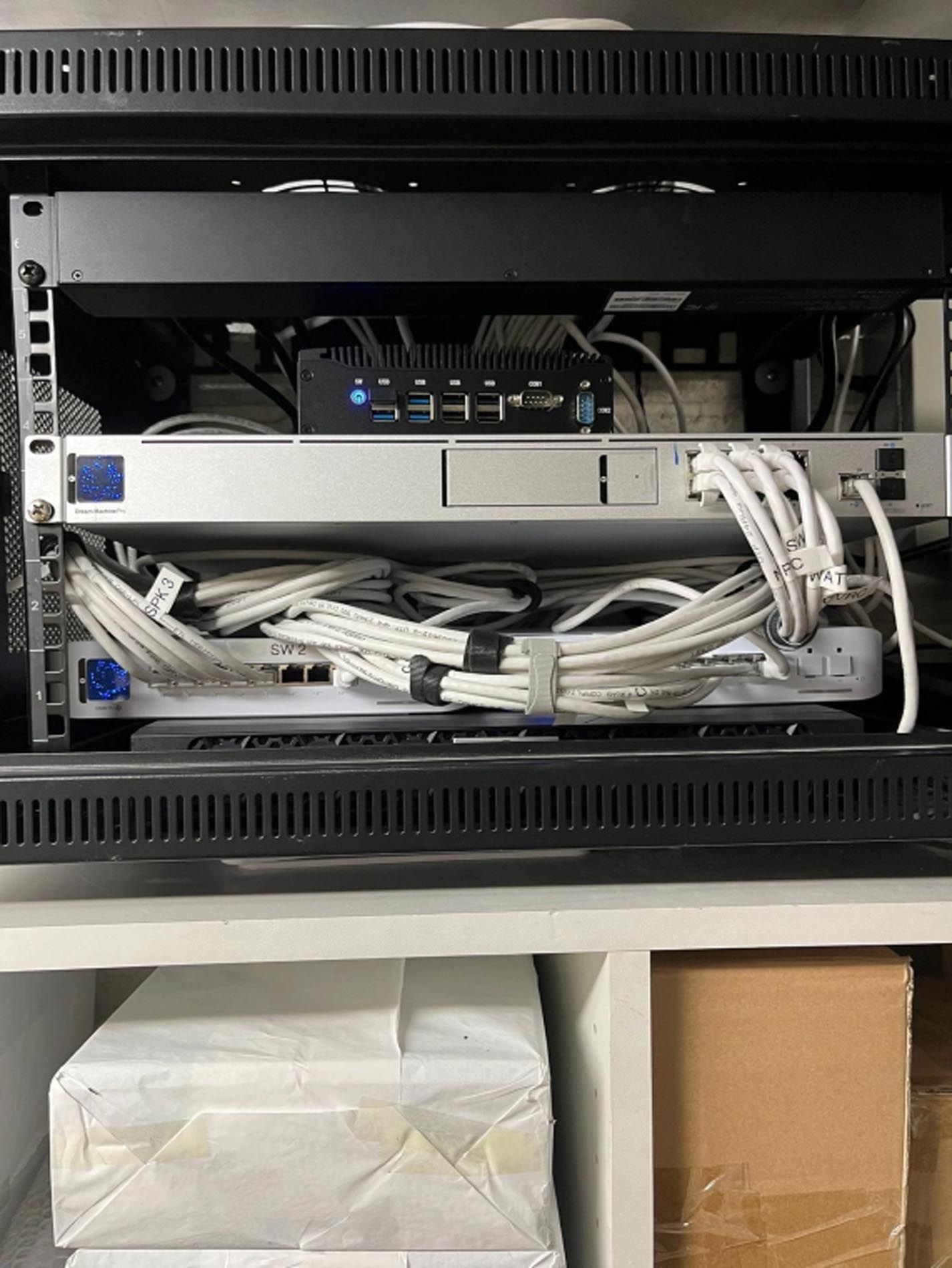 The back of a server rack with a lot of wires coming out of it.