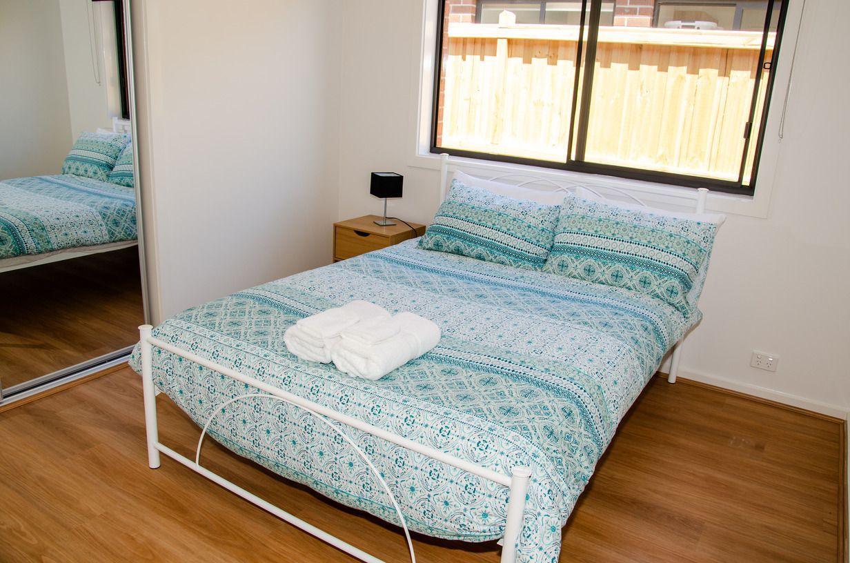 A bedroom with a bed and a mirror