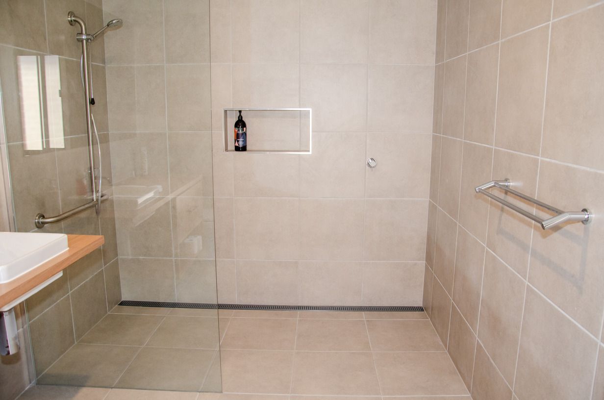 A bathroom with a walk in shower and a sink.
