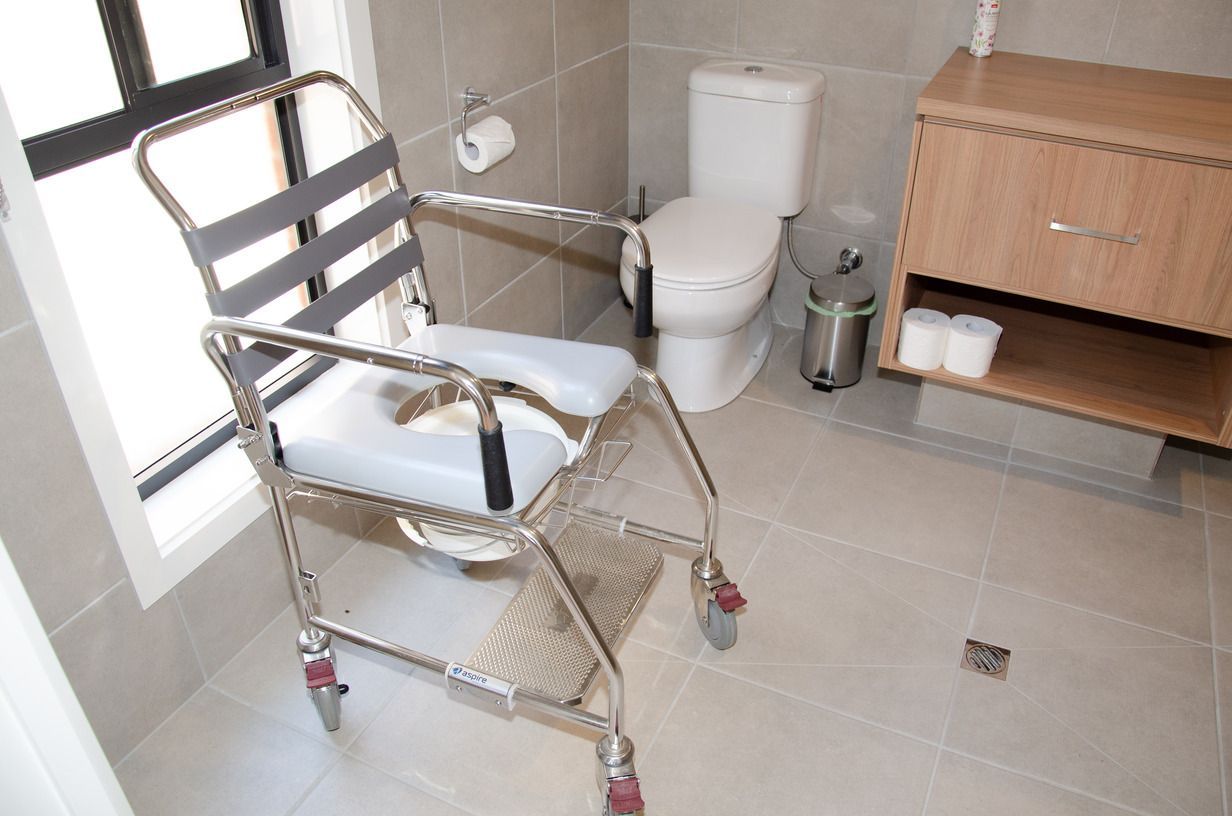 A wheelchair is sitting in a bathroom next to a toilet.