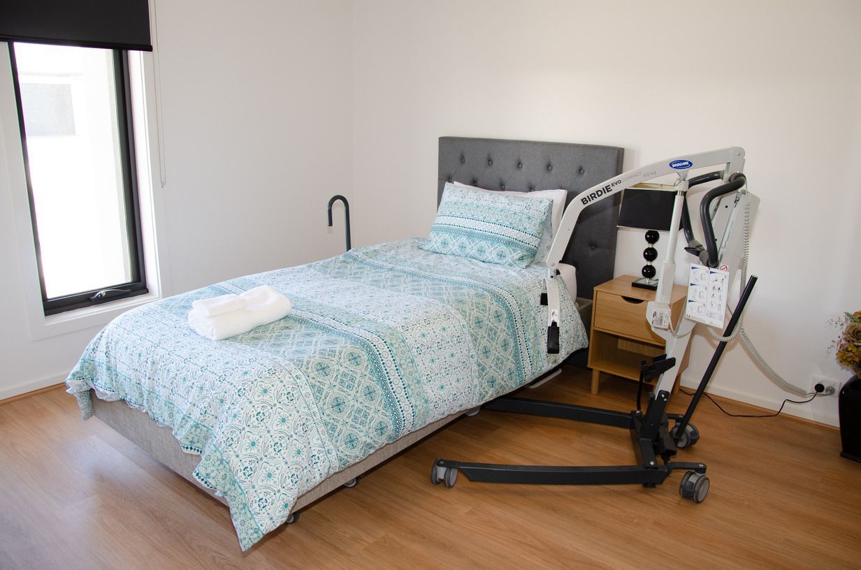 A bedroom with a bed and a wheelchair in it.