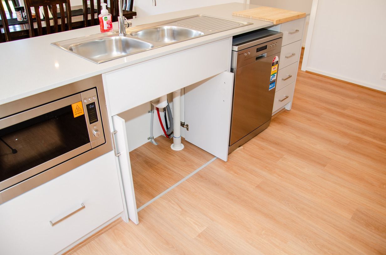A kitchen with two sinks , a microwave and a dishwasher