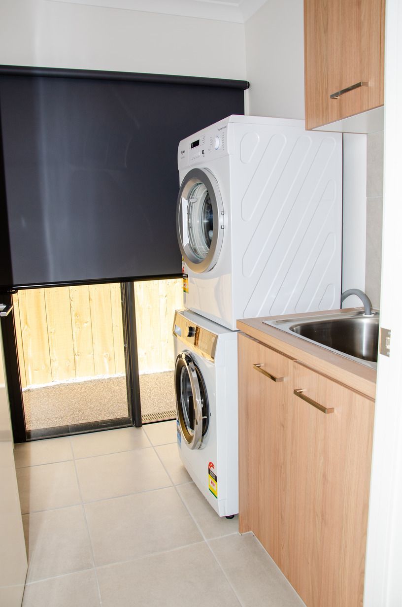 A laundry room with a washer and dryer stacked on top of each other.