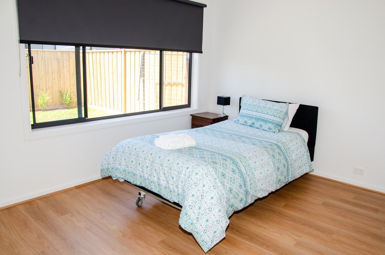 There is a bed in the middle of the room with a window.