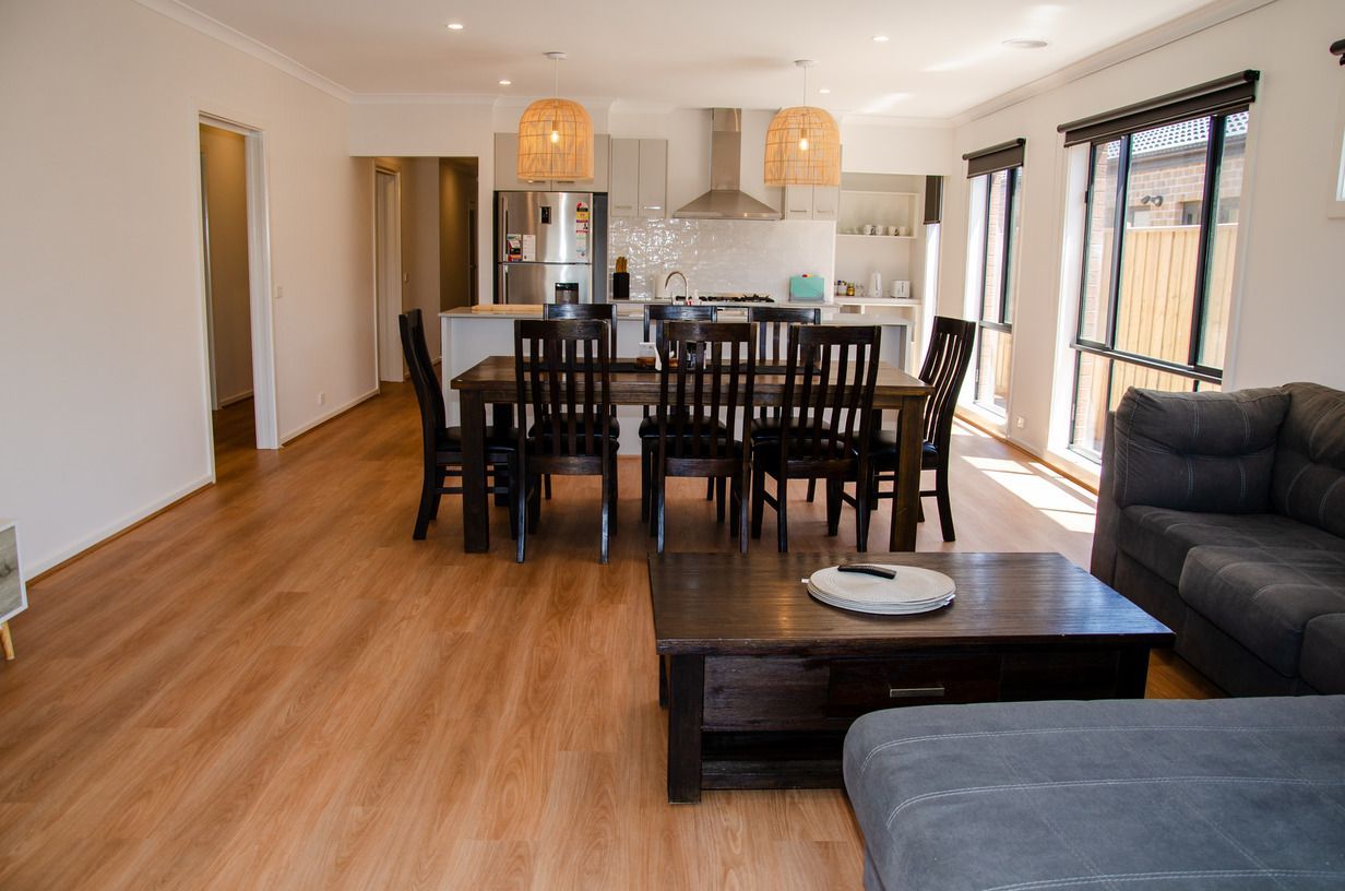 A living room with a dining table and chairs and a couch.