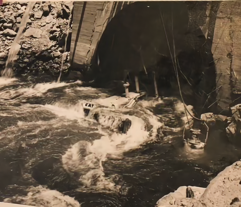 A black and white photo of a river with a sign that says cat