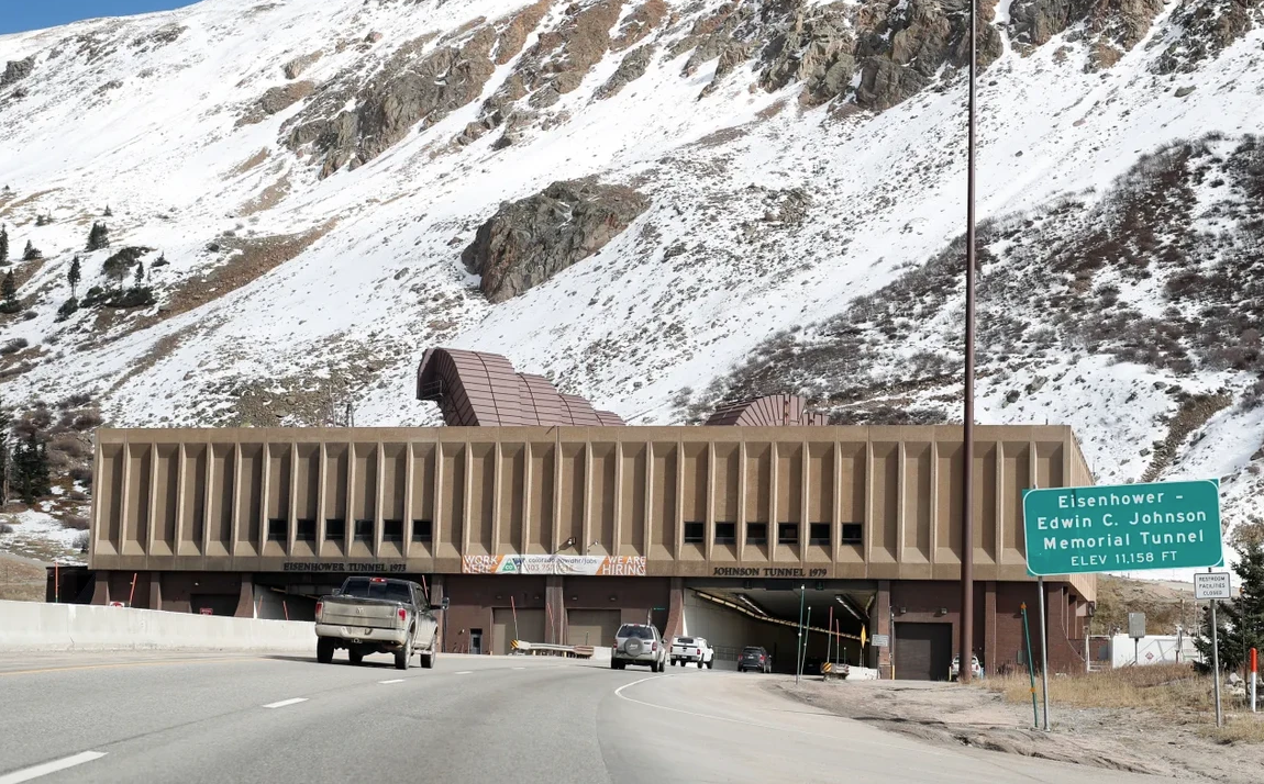 A car is driving through a tunnel in the mountains.