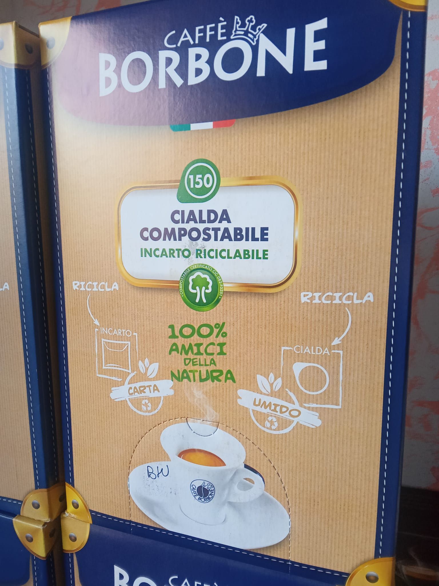 una scatola di caffè borbone con una tazza di caffè su un piattino