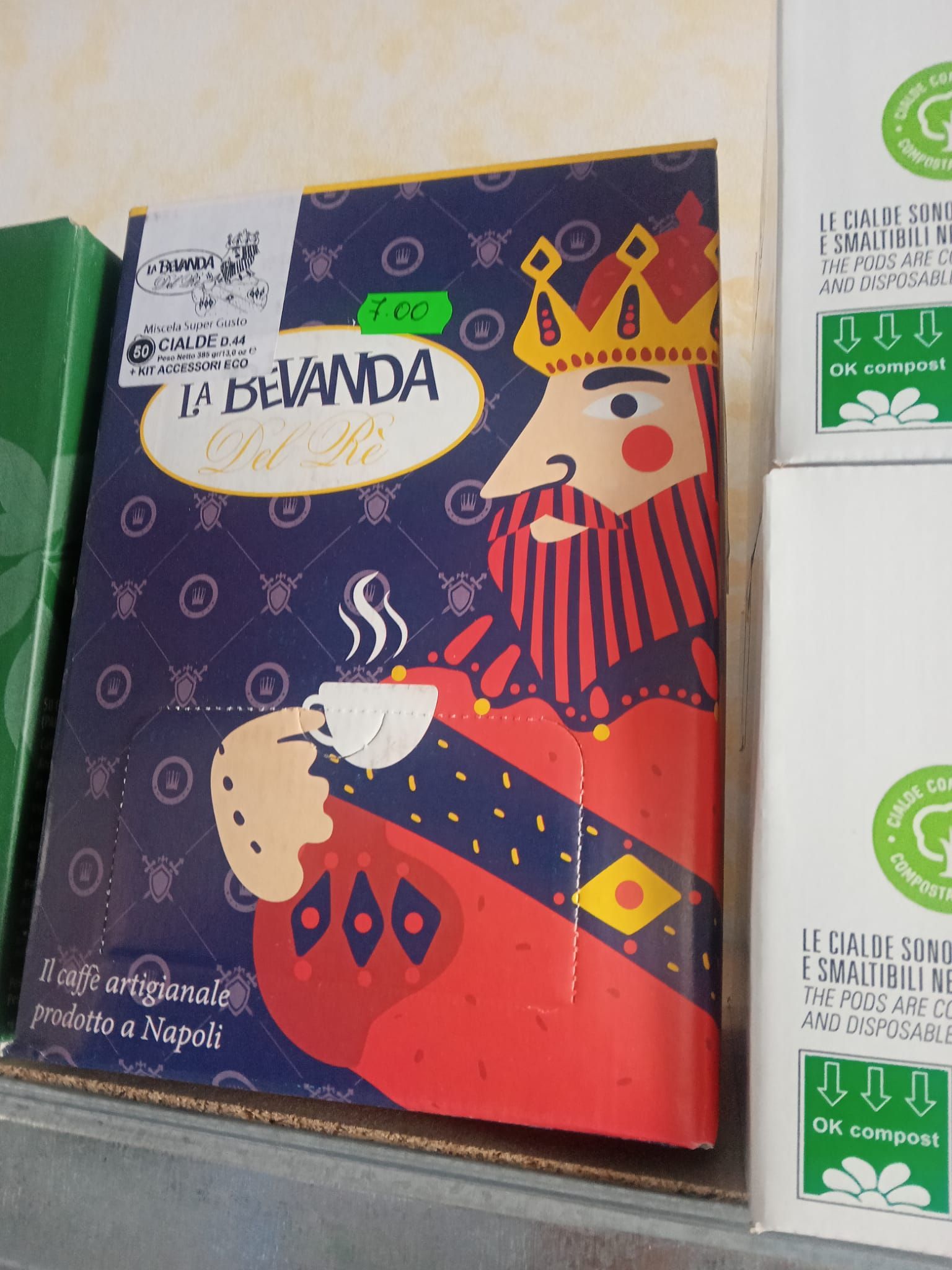 una scatola di caffè con un re che tiene in mano una tazza di caffè