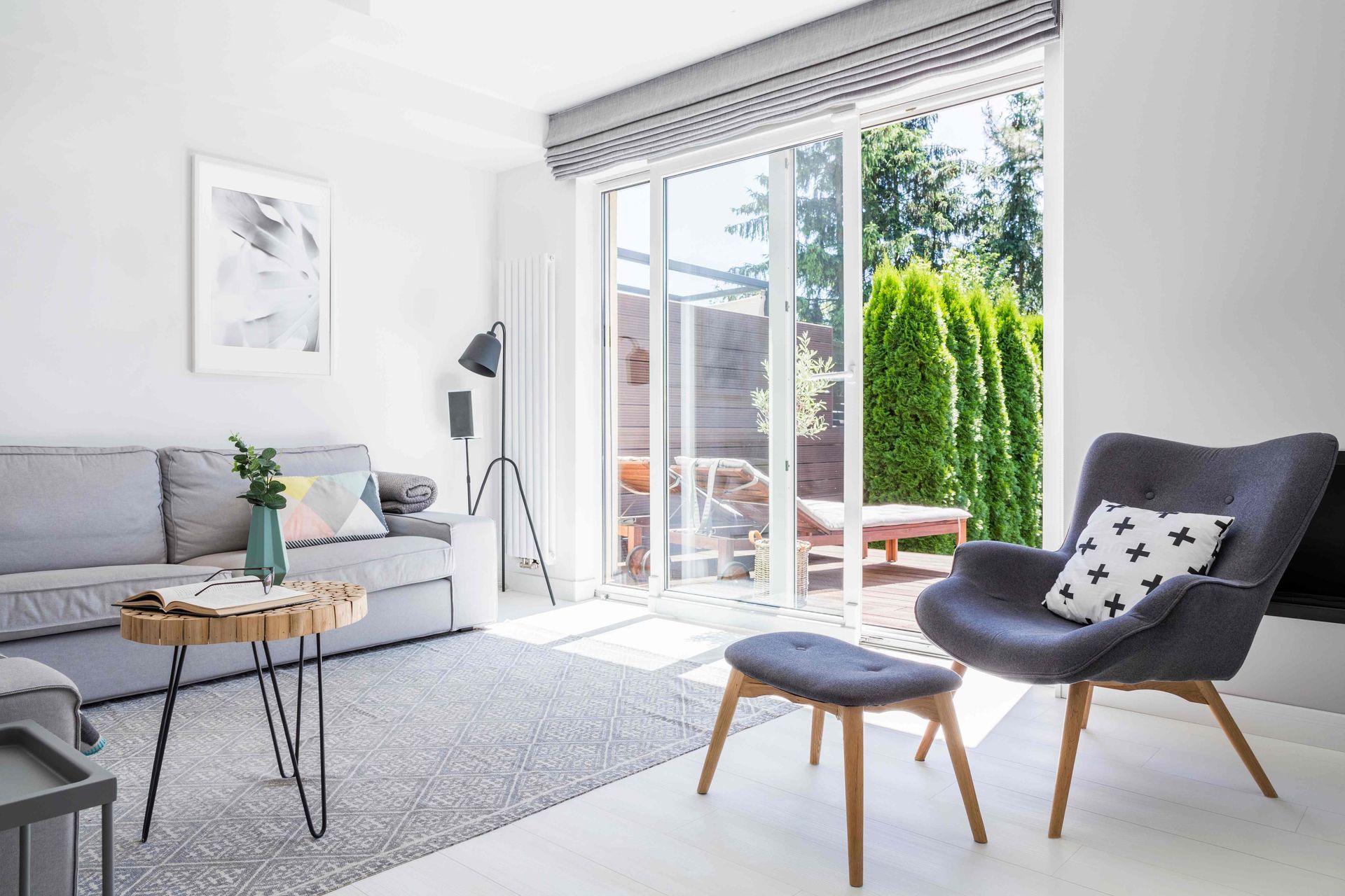 Furnished living room with patio door that leads out to backyard patio at LC Window Treatments near 