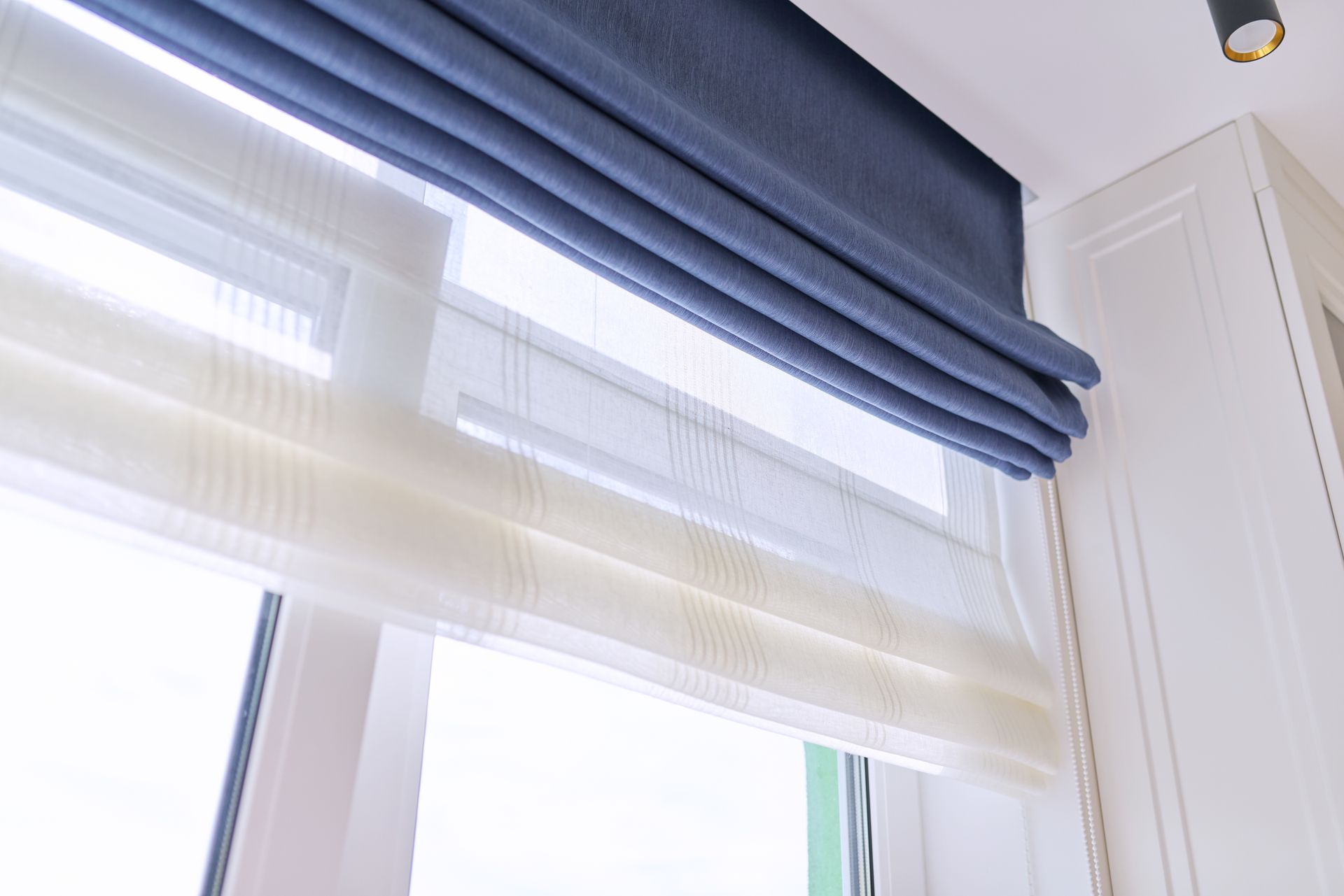 Dark blue window shades covering a large window. 