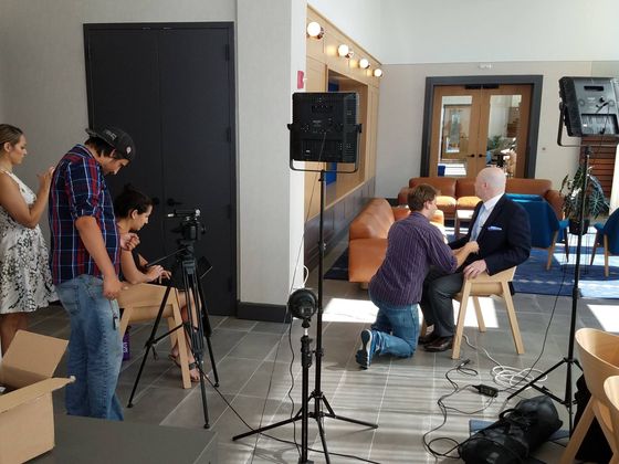 Behind-the-scenes photo of Calvisions filming a video profile for Related Realty, showing camera crew, lighting setup, and on-location production.
