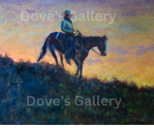 Cowboy on horseback against a colorful sunset.