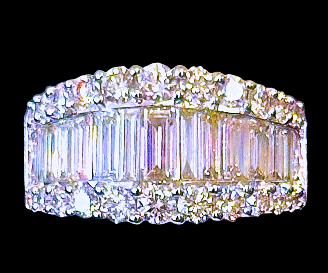 Diamond ring with a row of baguettes and surrounding round stones.