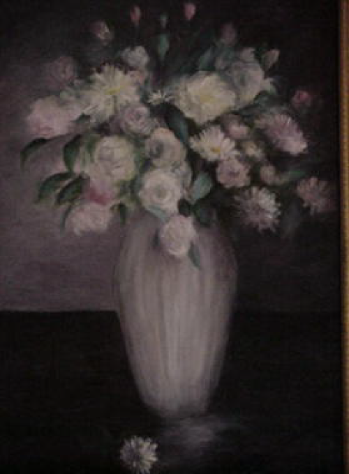 White flowers in a vase on a dark surface.