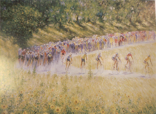 Cyclists racing uphill on a dirt road, amidst yellow flowers and trees.