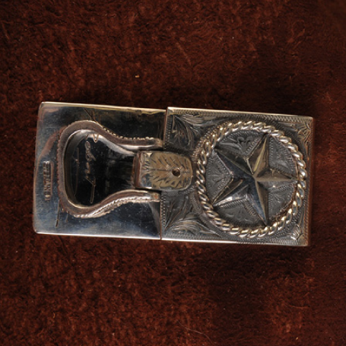 Silver belt buckle with a Texas star design and ornate engraving.