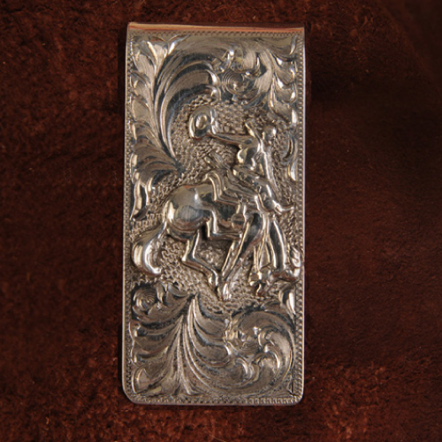 Silver money clip, detailed with a cowboy on a bucking horse, surrounded by floral flourishes.