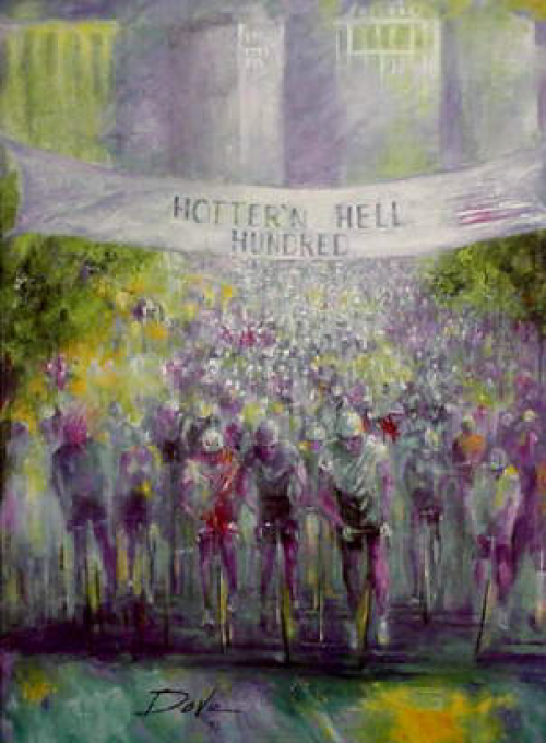 Cyclists racing towards finish line banner that reads “Hotter's Hell Nunukee,” amid a crowd, with a light-colored building in the background.