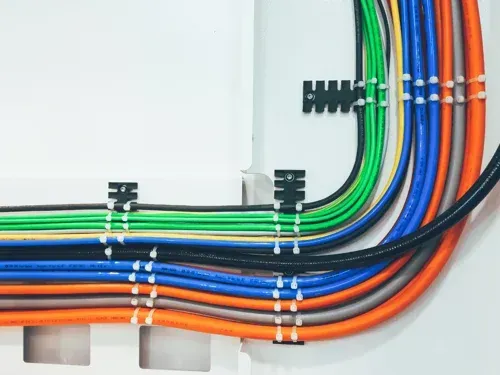 A bunch of colorful wires are connected to a wall.