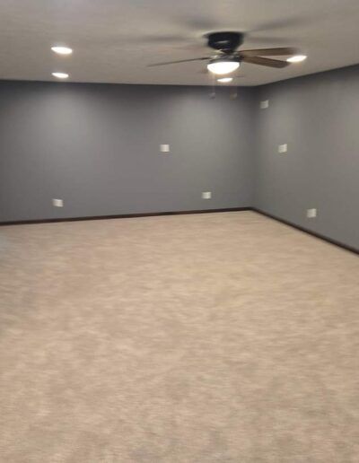 Empty room with gray walls, beige carpet, recessed lights, and ceiling fan.
