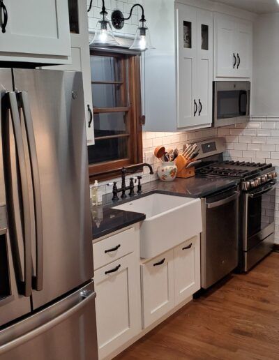 Kitchen with white cabinets, stainless steel appliances, and a farmhouse sink.