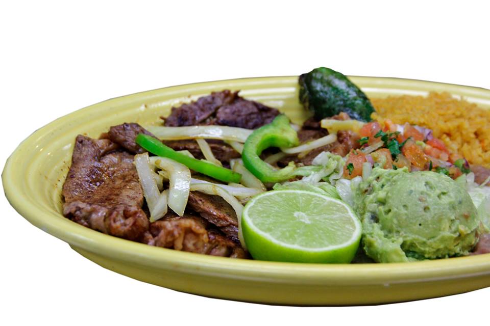 A yellow plate topped with meat , vegetables , guacamole and rice.