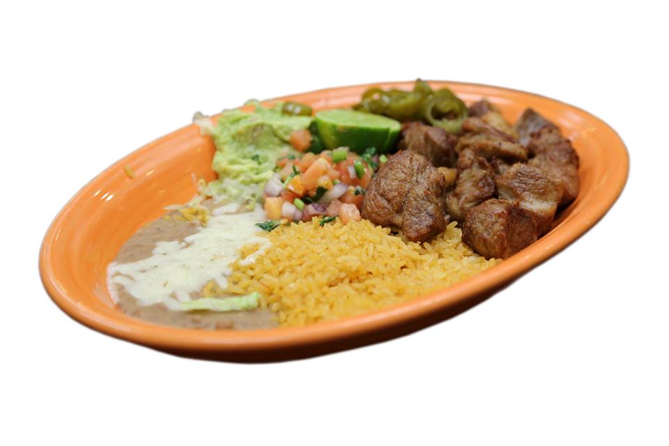 A plate of food with meat , rice and beans on a white background.
