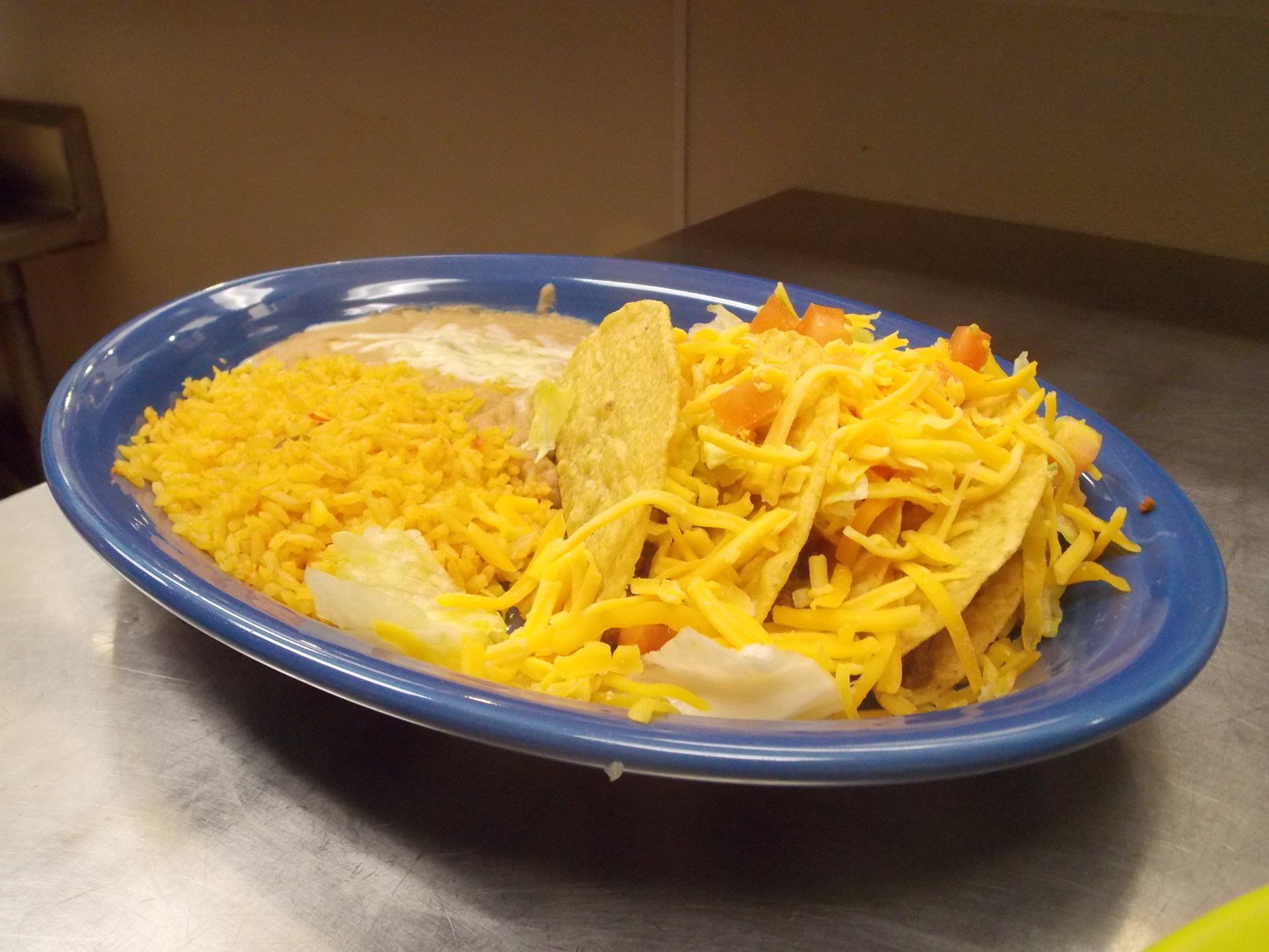 A blue plate with rice and tacos on it