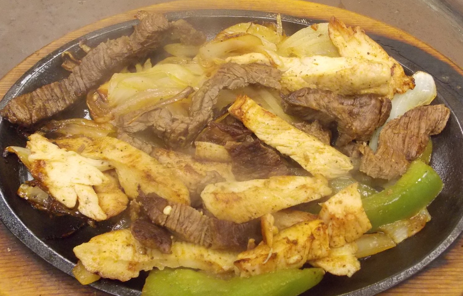 A close up of a plate of food on a wooden table.