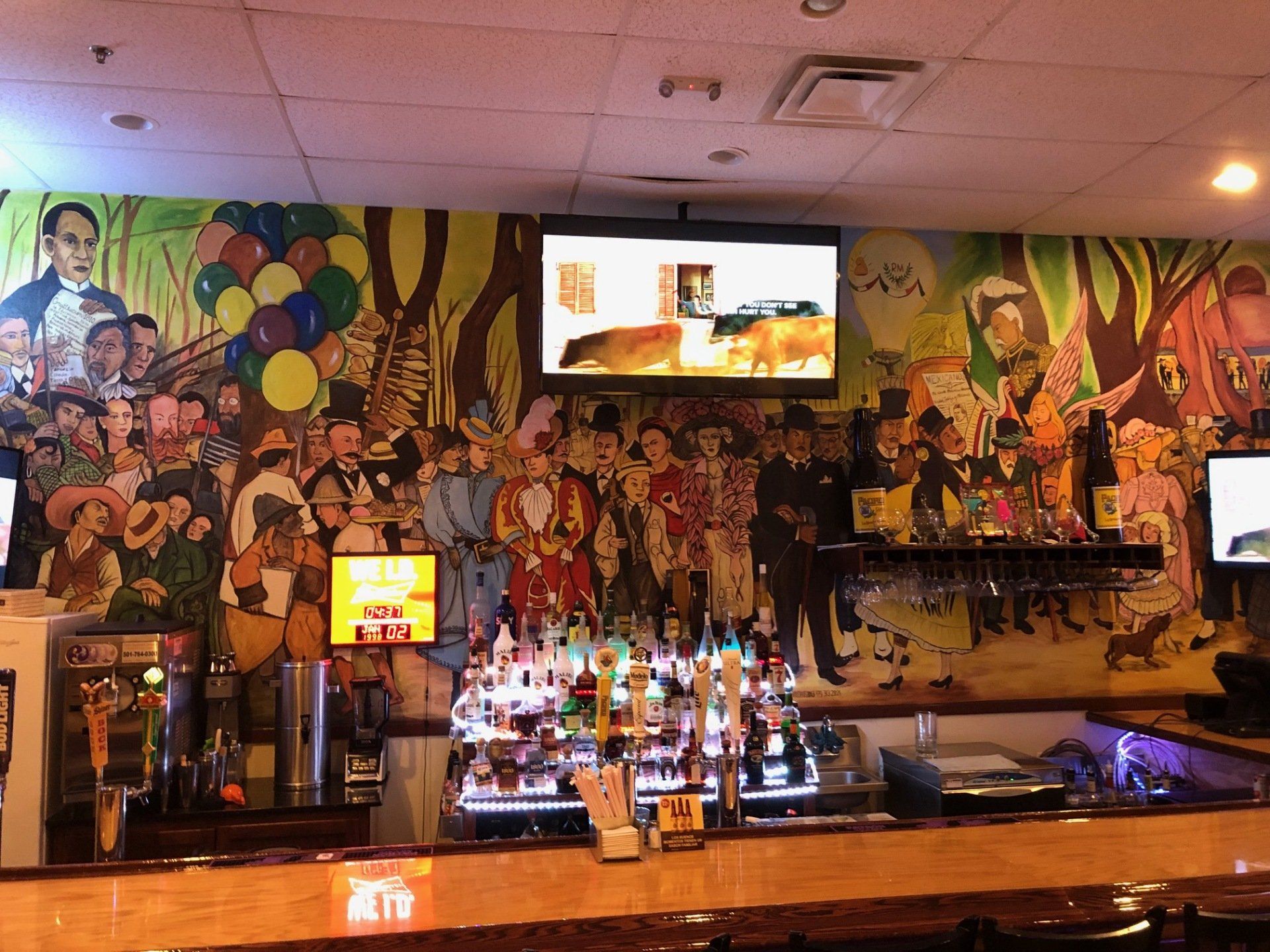 A bar with a large mural on the wall behind it