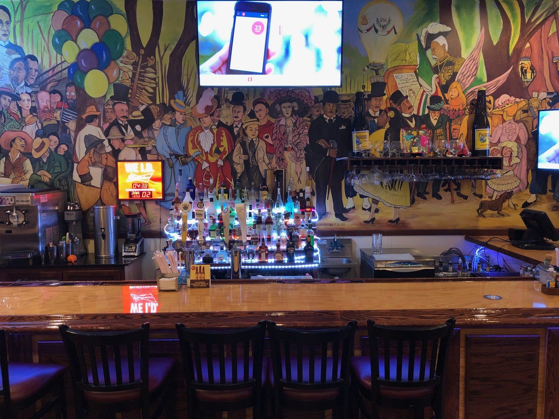 A bar with a large mural on the wall behind it