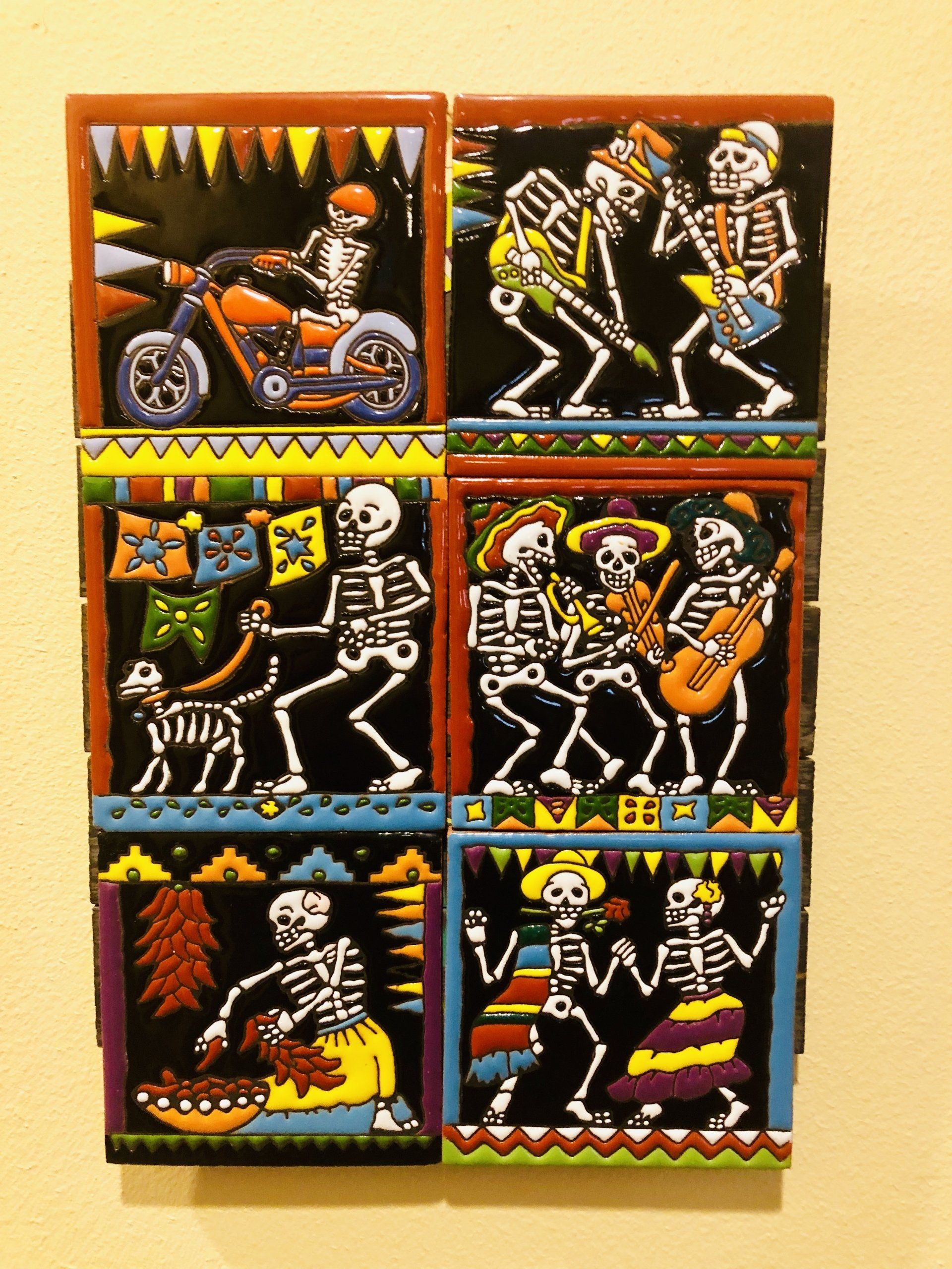 A set of four tiles with skeletons on them
