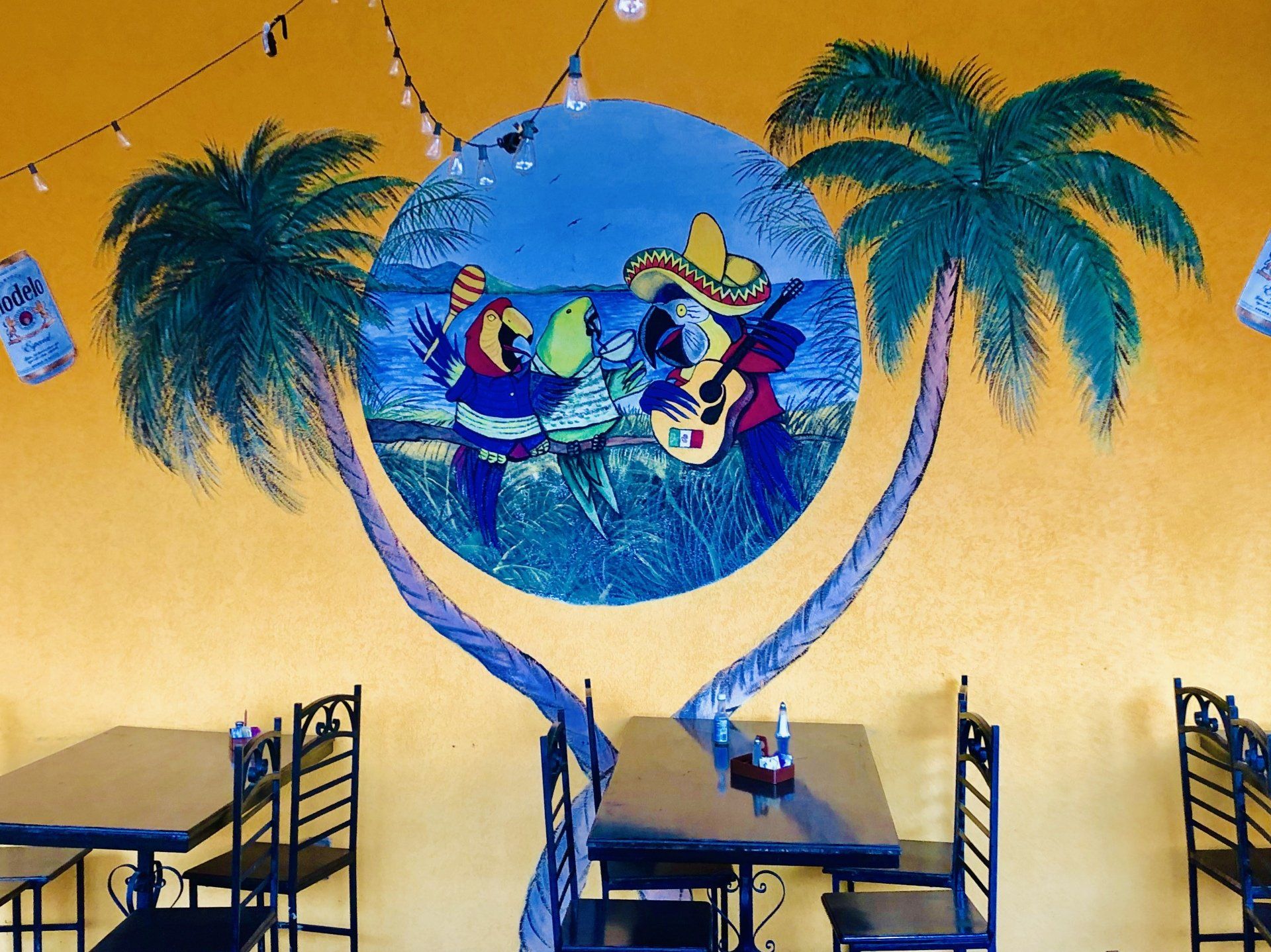 A restaurant with tables and chairs and a painting on the wall