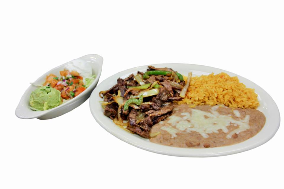 A plate of mexican food with beans , rice and guacamole on a white background.