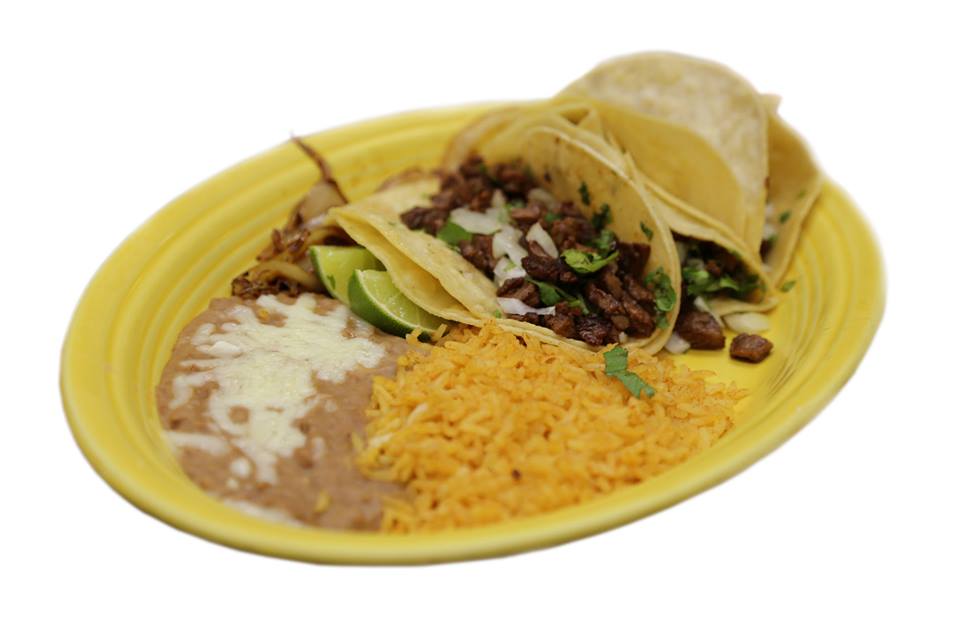 A yellow plate topped with tacos beans and cheese