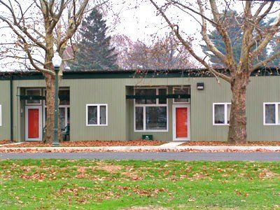 A green building with red doors and windows