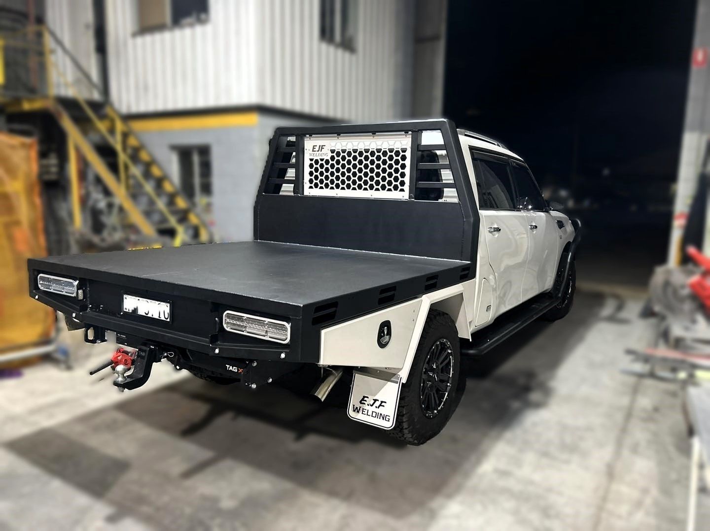 A White Truck with A Black Bed Is Parked in Front of A Building — EJF Built in Dubbo, NSW