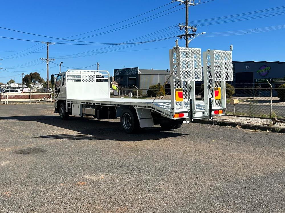 A White Flatbed Truck Is Parked in A Parking Lot — EJF Welding in Dubbo, NSW