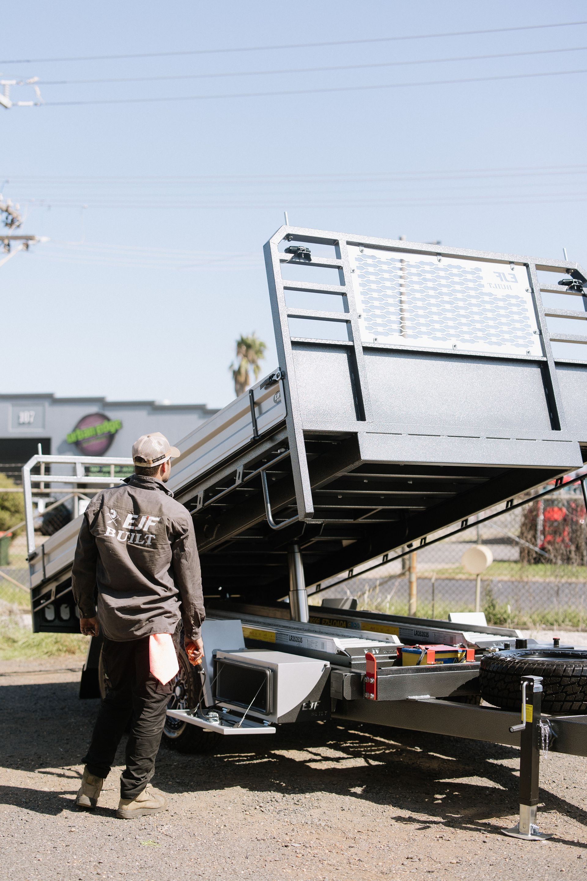 Man Inspecting a Black Trailer Bed  — EJF Built in Dubbo, NSW