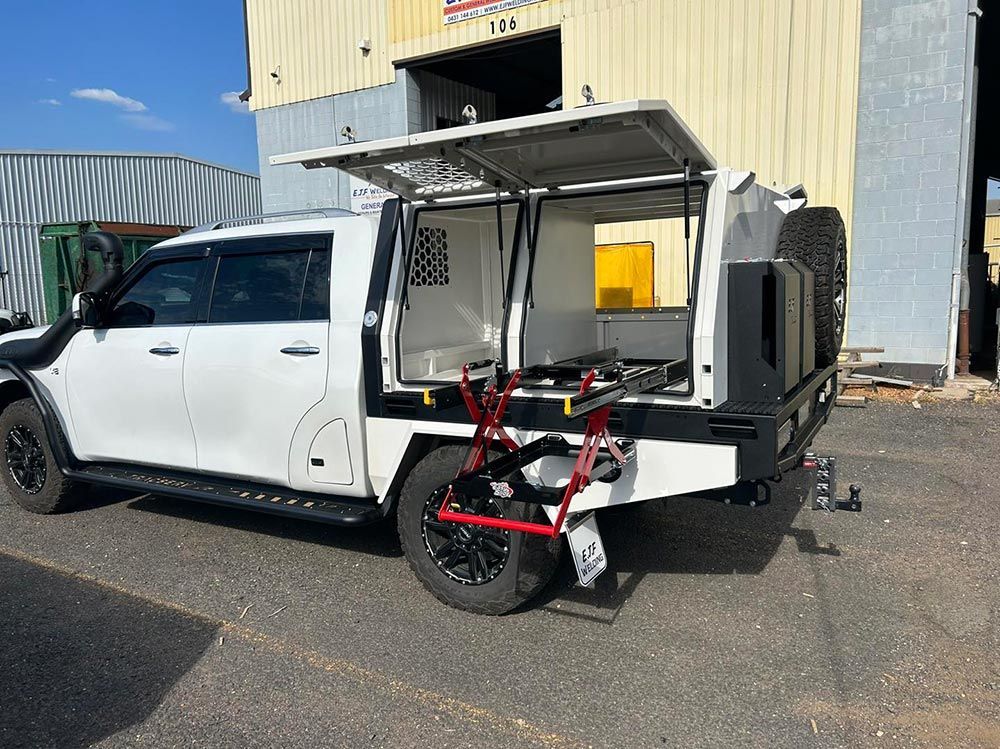 A White Truck With A Canopy Is Parked In Front Of A Building — EJF Built in Dubbo, NSW