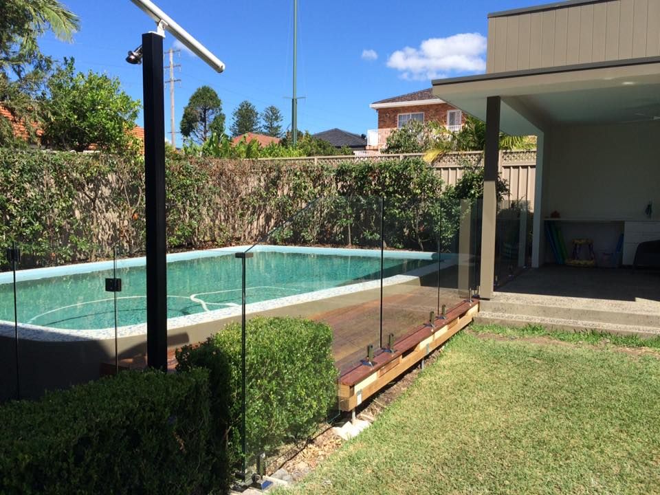 A Rectangular Backyard Swimming Pool With Light Blue Water — ClearView Glass Pool Fencing In Roselands, NSW
