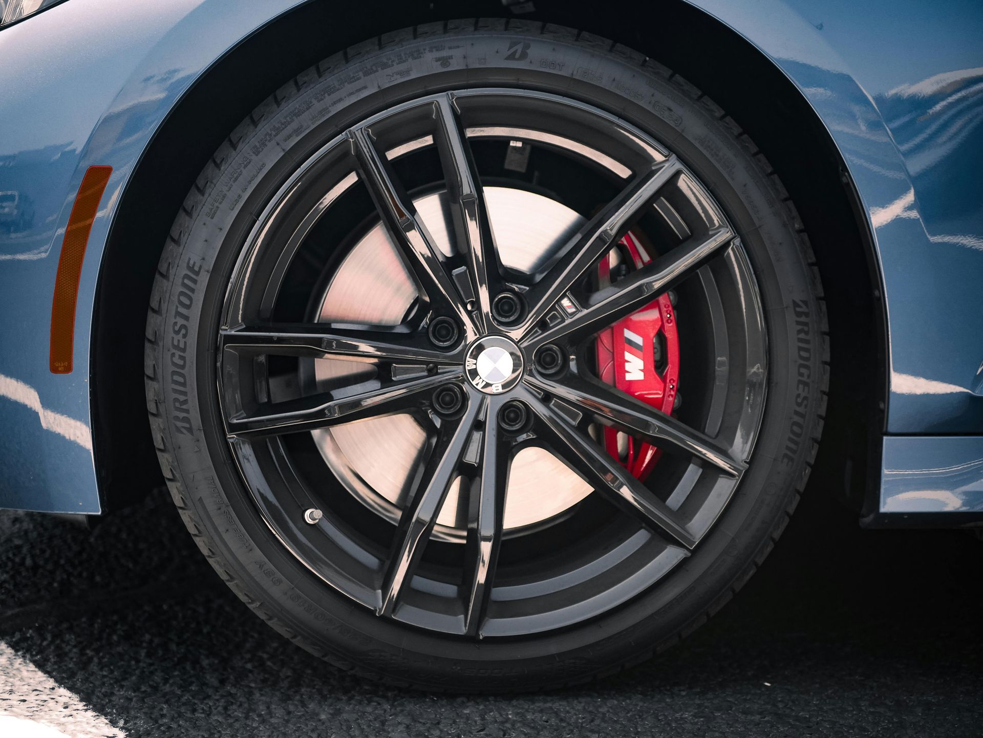 A close up of a car wheel with red brake calipers