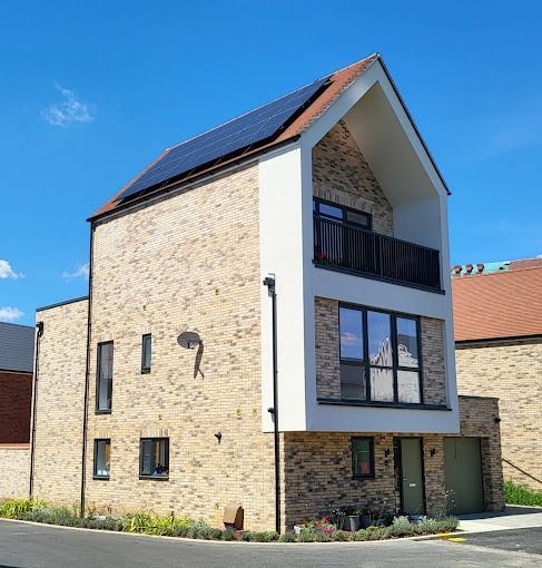 A brick house with a balcony and solar panels on the roof